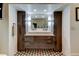 Symmetrical bathroom with a dual vanity, modern lighting, and stylish brown cabinets at 6341 Discovery Ln, Land O Lakes, FL 34638