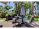 Outdoor dining set on a deck with views of the lush backyard and mature trees at 6341 Discovery Ln, Land O Lakes, FL 34638
