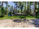 A lakeside home is seen through the trees with a small shed and two kayaks on the side at 6341 Discovery Ln, Land O Lakes, FL 34638