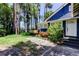 A walkway with gray pavers leads to a side entrance of a blue home with a deck at 6341 Discovery Ln, Land O Lakes, FL 34638