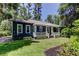Charming blue home with a metal roof, white pergola, and well-manicured lawn at 6341 Discovery Ln, Land O Lakes, FL 34638