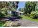 Blue home with metal roof, front lawn, and a long paved driveway leading up to it at 6341 Discovery Ln, Land O Lakes, FL 34638