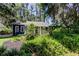 Charming home exterior with lush landscaping, a metal roof, and a cozy front porch at 6341 Discovery Ln, Land O Lakes, FL 34638