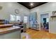 Bright kitchen with natural wood floors, sage cabinets, stainless appliances, and a view of the living area at 6341 Discovery Ln, Land O Lakes, FL 34638
