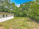 The backyard has a small grassy area, enclosed by a fence and a few scattered plants at 6901 N 19Th St, Tampa, FL 33610