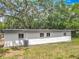 The backyard of the house is big with a central AC unit and a small window at 6901 N 19Th St, Tampa, FL 33610