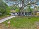 Inviting single-story home with lush lawn, mature trees, and a private screened-in porch at 6901 N 19Th St, Tampa, FL 33610