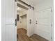 Hallway featuring stylish sliding barn door adding a touch of rustic charm to the interior at 6901 N 19Th St, Tampa, FL 33610