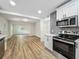 Newly renovated kitchen with modern appliances, gray backsplash, and hardwood floors at 6901 N 19Th St, Tampa, FL 33610