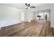 Open-concept living room with hardwood floors and modern ceiling fan, flowing into the kitchen at 6901 N 19Th St, Tampa, FL 33610