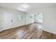Open-concept living room featuring wood-look floors, white walls, and natural light from the windows at 6901 N 19Th St, Tampa, FL 33610