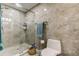 This bathroom features grey marbled tile, a glass enclosed shower and modern fixtures at 706 Kingswood Loop, Brandon, FL 33511