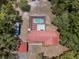 Birds eye view of home with a red metal roof and a screened-in pool surrounded by lush Florida trees at 7095 South St, Webster, FL 33597