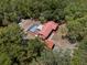 Aerial view of a house with a screened-in pool and lush greenery surrounding the property at 7095 South St, Webster, FL 33597