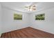 This bright bedroom features two windows and wood flooring at 7095 South St, Webster, FL 33597
