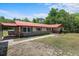 Front exterior view featuring red roof, brick accents, and walkway at 7095 South St, Webster, FL 33597