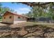 View of home featuring a screened in pool and enclosed patio with low pitched metal roof and lush trees at 7095 South St, Webster, FL 33597