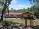 Charming single story home with a red roof and manicured front lawn at 7095 South St, Webster, FL 33597