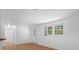 Bright living room with hardwood floors, natural light from the window, and entryways at 7095 South St, Webster, FL 33597