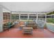 Relaxing screened porch features neutral wicker furniture and a view of the backyard at 7095 South St, Webster, FL 33597