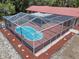 Aerial view of a private screened-in pool with stone pavers and surrounding foliage at 7095 South St, Webster, FL 33597