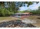 View of home featuring a screened-in pool and enclosed patio area with low pitched red metal roof at 7095 South St, Webster, FL 33597