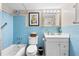 Classic blue tiled bathroom features a tub/shower combo, vanity and a decorative mirror at 7200 Sunshine Skyway S Ln # 4B, St Petersburg, FL 33711