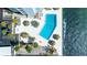 Aerial view of condo pool deck with uniquely shaped pool, lush landscaping, and lounging area at 7200 Sunshine Skyway S Ln # 4B, St Petersburg, FL 33711