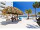 Poolside shaded patio with tables and seating, palm trees and water view at 7200 Sunshine Skyway S Ln # 4B, St Petersburg, FL 33711