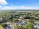 Expansive aerial view of a neighborhood with lush greenery, showcasing homes, streets, and community layout under a clear blue sky at 7325 Calder Dr, New Port Richey, FL 34653