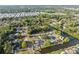 Aerial view of a community featuring tree-lined streets, homes with swimming pools, and a tranquil river winding through the neighborhood at 7325 Calder Dr, New Port Richey, FL 34653