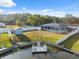 Aerial view of a spacious backyard, featuring a pool, shed, and waterfront access with a wooden deck at 7325 Calder Dr, New Port Richey, FL 34653
