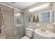 Neutral tiled bathroom featuring a sliding glass shower door, mirror, toilet, and vanity with sink at 7325 Calder Dr, New Port Richey, FL 34653