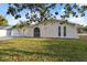 Charming home exterior with stucco walls, arched entry and palm tree at 7325 Calder Dr, New Port Richey, FL 34653