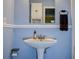 Bathroom with blue walls, white pedestal sink and matching white medicine cabinet at 8497 137Th St, Seminole, FL 33776
