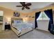 Comfortable bedroom with neutral walls, a ceiling fan, and large window for plenty of natural light at 8497 137Th St, Seminole, FL 33776