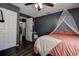 Bedroom with dark gray walls, white trim, hardwood flooring, and canopy at 8497 137Th St, Seminole, FL 33776
