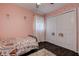 Charming bedroom featuring light pink walls, wood-look floors, and white closet with rainbow decor at 8497 137Th St, Seminole, FL 33776