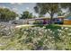 Inviting single-story home featuring a lush front yard filled with colorful flowers and a vibrant red front door at 8497 137Th St, Seminole, FL 33776
