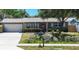 Charming single-story home with a well-manicured lawn, bright red front door, and attached garage at 8497 137Th St, Seminole, FL 33776