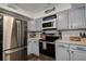 Charming kitchen featuring stainless steel appliances, gray shaker cabinets, and light countertops at 8497 137Th St, Seminole, FL 33776
