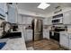 Galley kitchen featuring stainless steel appliances, white shaker cabinets, and light countertops at 8497 137Th St, Seminole, FL 33776