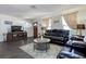 Comfortable living room with dark wood floors, a black leather sofa set, and natural light from the windows at 8497 137Th St, Seminole, FL 33776