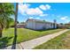 Gray single-story home featuring white trim, green lawn, and concrete sidewalk at 8520 Woodall Ct, Tampa, FL 33615
