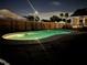 Night view of a private backyard pool illuminated for evening swims and relaxation, surrounded by a wooden fence at 8520 Woodall Ct, Tampa, FL 33615