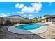 Backyard featuring a kidney-shaped pool with concrete surround, partial view of home, and wood privacy fence at 8520 Woodall Ct, Tampa, FL 33615