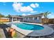 Backyard showcasing a private pool and screened-in patio attached to a gray home with a wood fence at 8520 Woodall Ct, Tampa, FL 33615