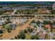 A wide aerial view of a neighborhood filled with houses, pools, green spaces, and a clear sky at 8926 Garner Ct, Trinity, FL 34655