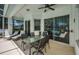 Covered outdoor patio with a dining set, ceiling fan, lounge chairs and view of the backyard pool through large sliding glass doors at 8926 Garner Ct, Trinity, FL 34655
