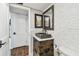 Charming powder room featuring a stone vessel sink and wood-look flooring at 9425 Blind Pass Rd # 802, St Pete Beach, FL 33706